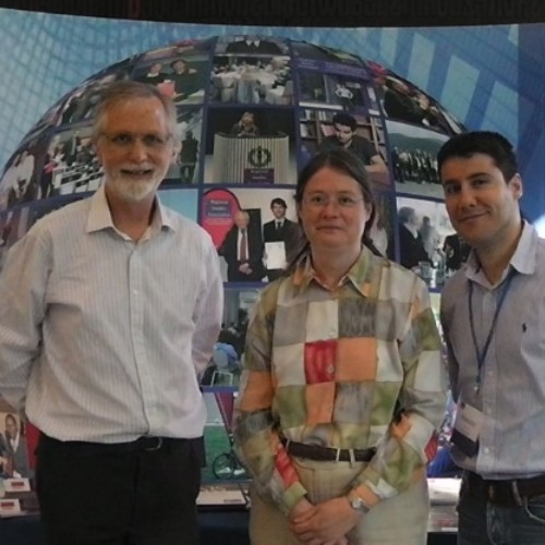 Three people standing in front of a poster presentation.
