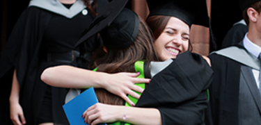 Students hugging at graduation ceremony 