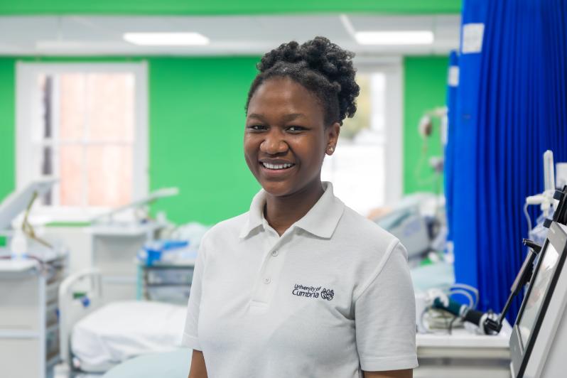 A UoC student helps people at an open day.