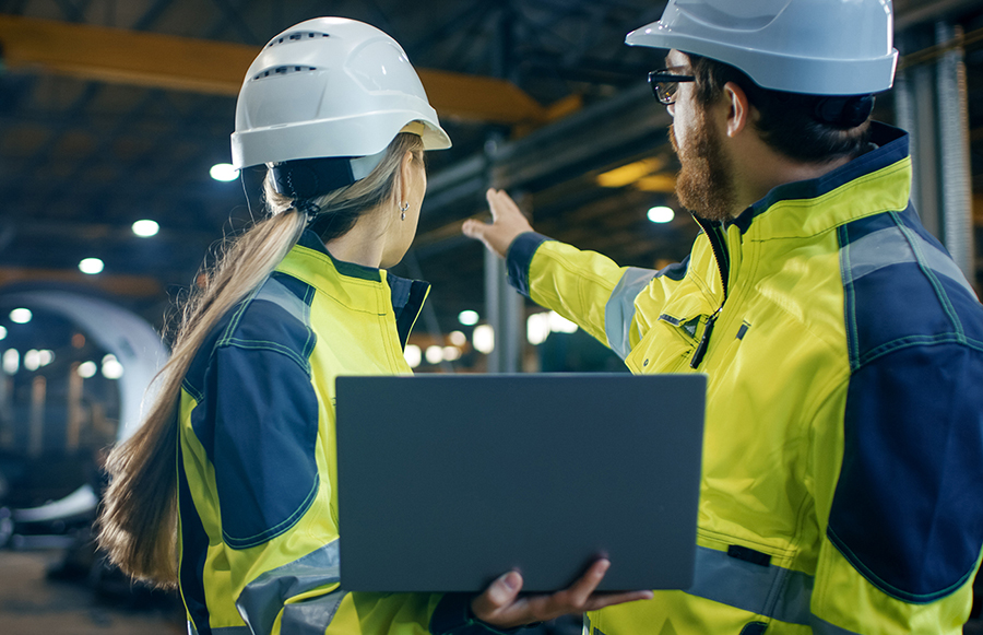 two apprentices in hi-vis jackets talking